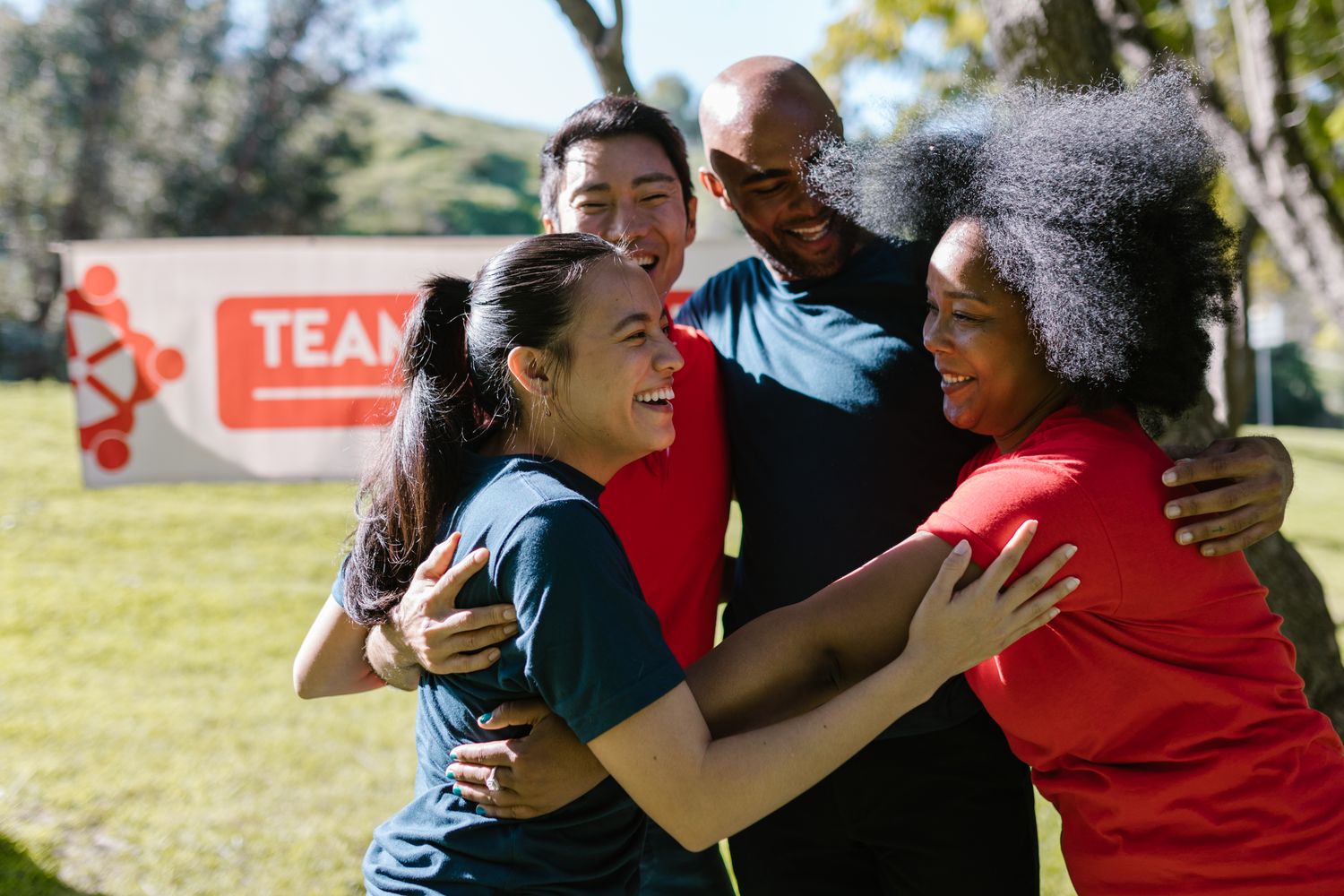 A group of volunteers embracing outdoors at a community event